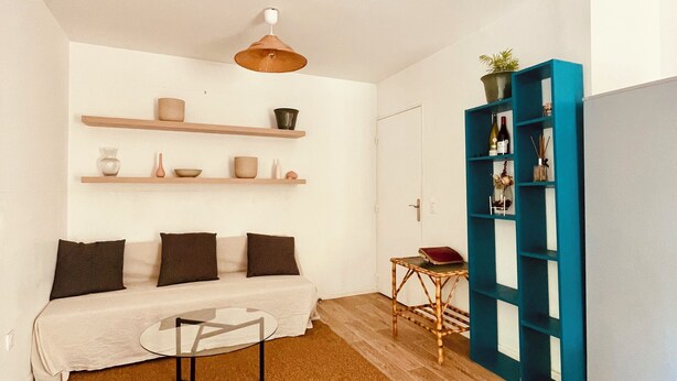 Ein Wohnzimmer mit Sofa, Couchtisch und Regalen an der Wand.