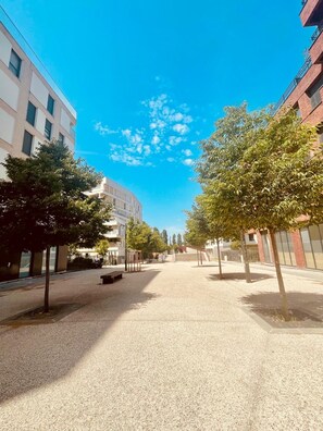 A spacious urban square with trees, benches, and modern buildings. - A cozy and spacious apartment just outside Paris. Perfect for families. (Noisy-le-Sec)
