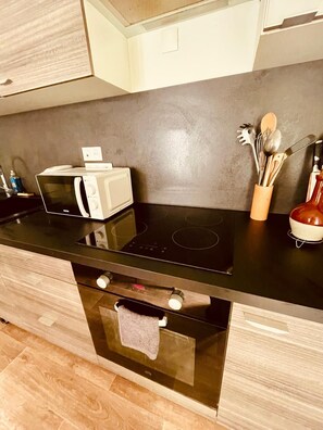 A modern kitchen with a microwave, stove, and oven. - A cozy and spacious apartment just outside Paris. Perfect for families. (Noisy-le-Sec)