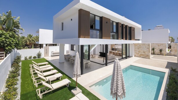 A modern two-story house with a swimming pool, outdoor seating, and a well-maintained garden. - New, 4 Bedroom Villa With Pool, 100 Meters From the Beach (Paralimni)
