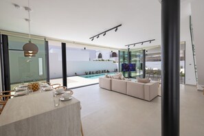 Ein modernes Interieur mit Essbereich, Pool und Sitzgelegenheit.