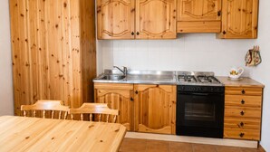 A kitchen with wooden cabinets, a stainless steel sink, a gas stove, and a built-in oven.