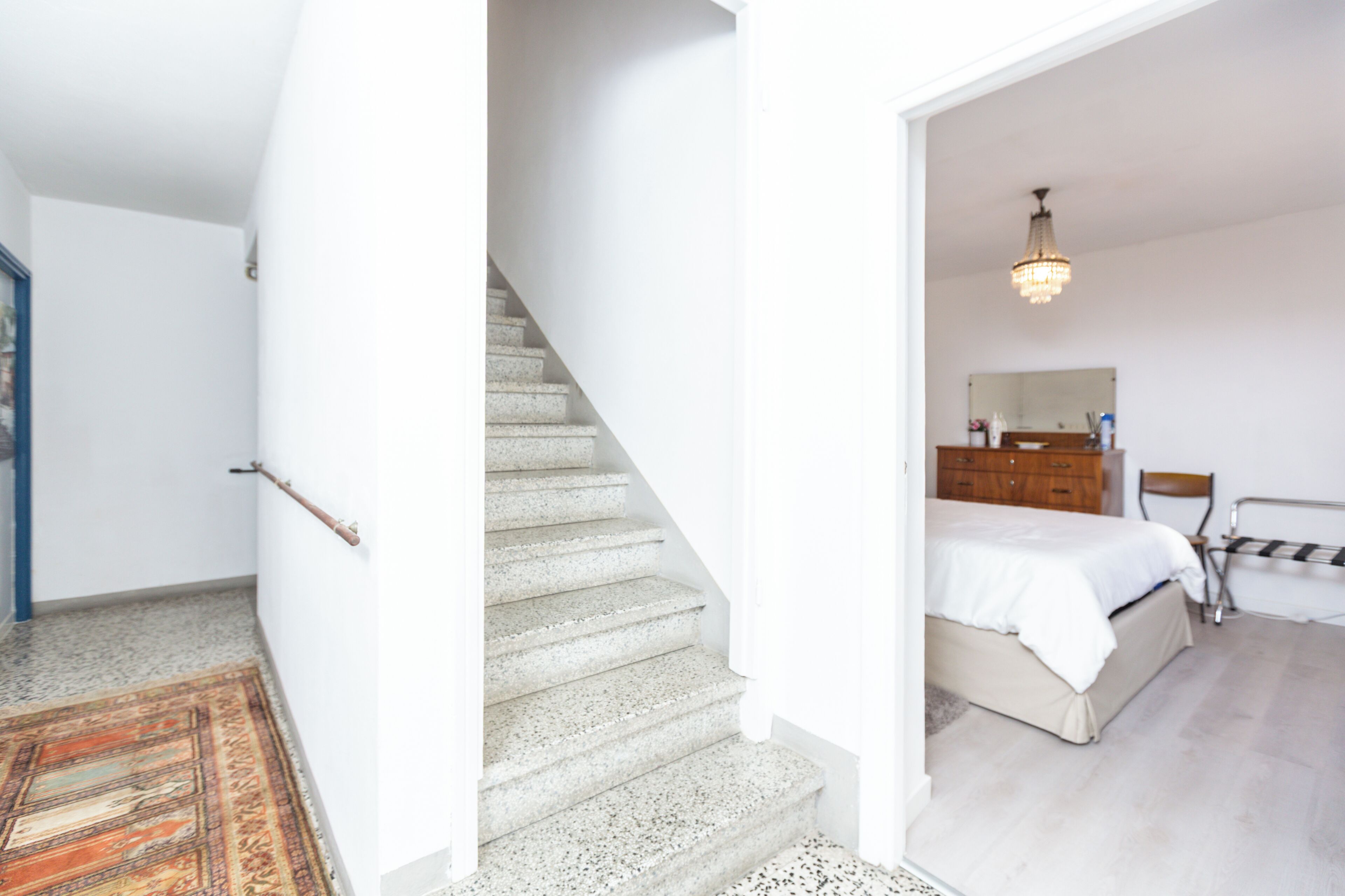 Un dormitorio con cama, cómoda y espejo.