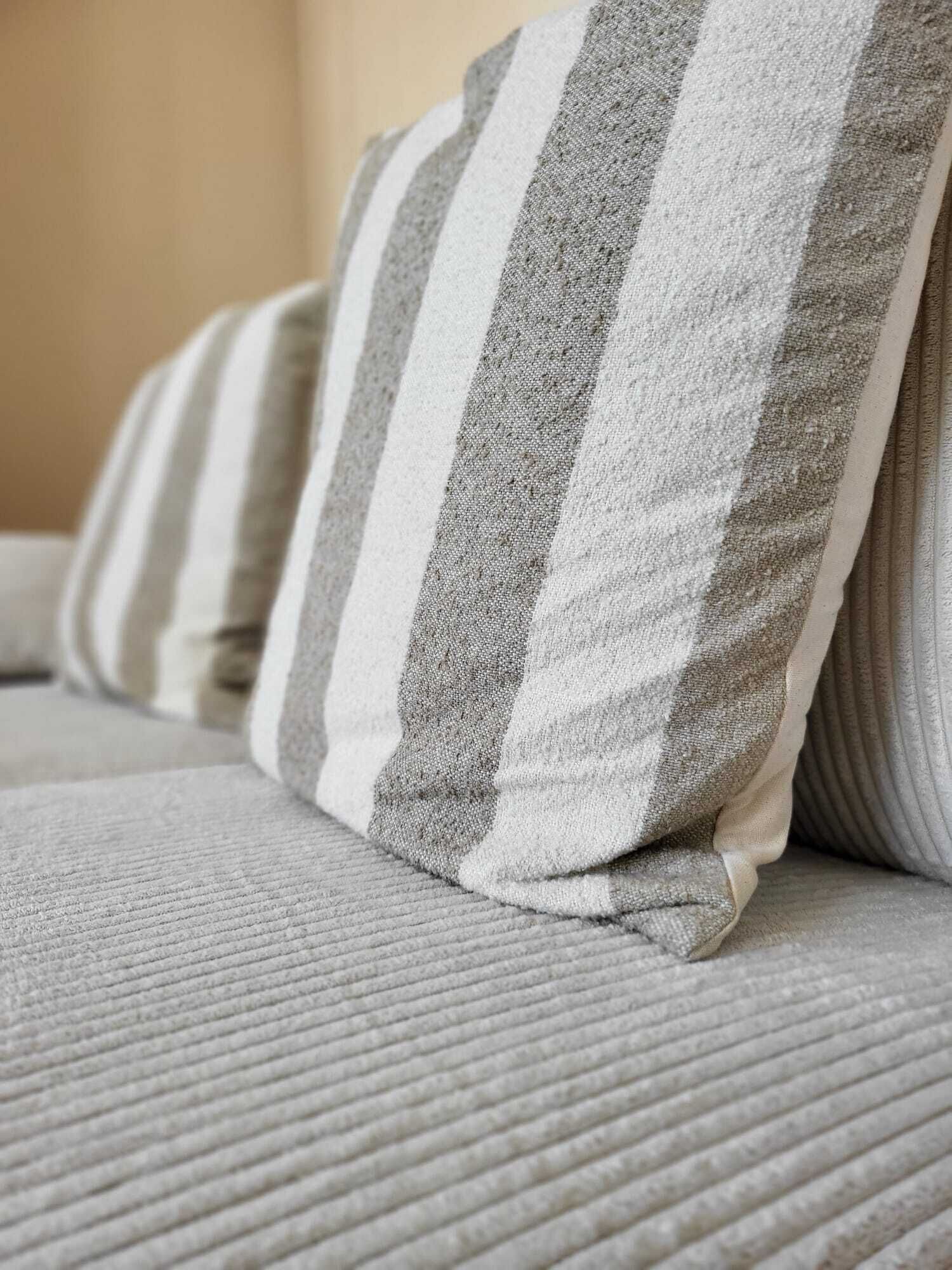 A close-up of a sofa with striped pillows.