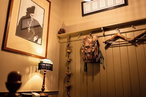 A room with a framed photograph on the wall, a lamp, a coat rack with a backpack, and a hanging coat. - Old Town Luxury, By The Sea - 3 en suite bedrooms, dog freindly (Scarborough)