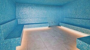 A swimming pool with tiled walls and a tiled floor, benches along the sides, and a light fixture on the ceiling. - Luxury Apartment Perfect for Holidays on the Coast (Gold Coast)