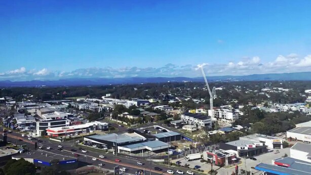 A commercial area with multiple buildings, roads, and a prominent tower structure. - Luxury Apartment Perfect for Holidays on the Coast (Gold Coast)