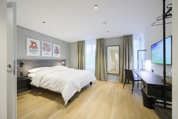 A modern hotel room with a bed, a desk, and a TV. - Hôtel Arnold & Co (Neuchâtel)