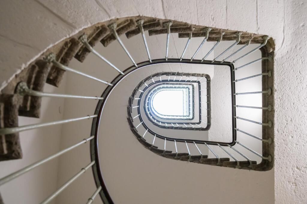 Eine Wendeltreppe mit Metallgeländern und einer weißen Wand.