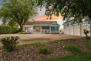 A two-story house with a covered porch, a driveway, and a garage. - Hoopers Landing | Private Dock | Hot Tub (Fishing Creek)