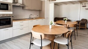 A modern kitchen with a dining area, including a round wooden table and chairs.