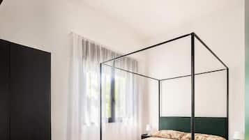 Un dormitorio moderno con una cama con dosel, un escritorio de madera y una silla.