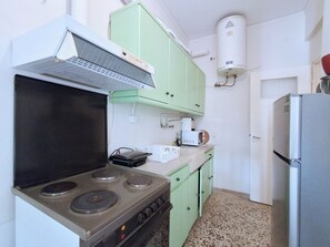 A compact kitchen with a stove, a sink, and a refrigerator. - Comfortable Apt near Larissis Metro (Athina)