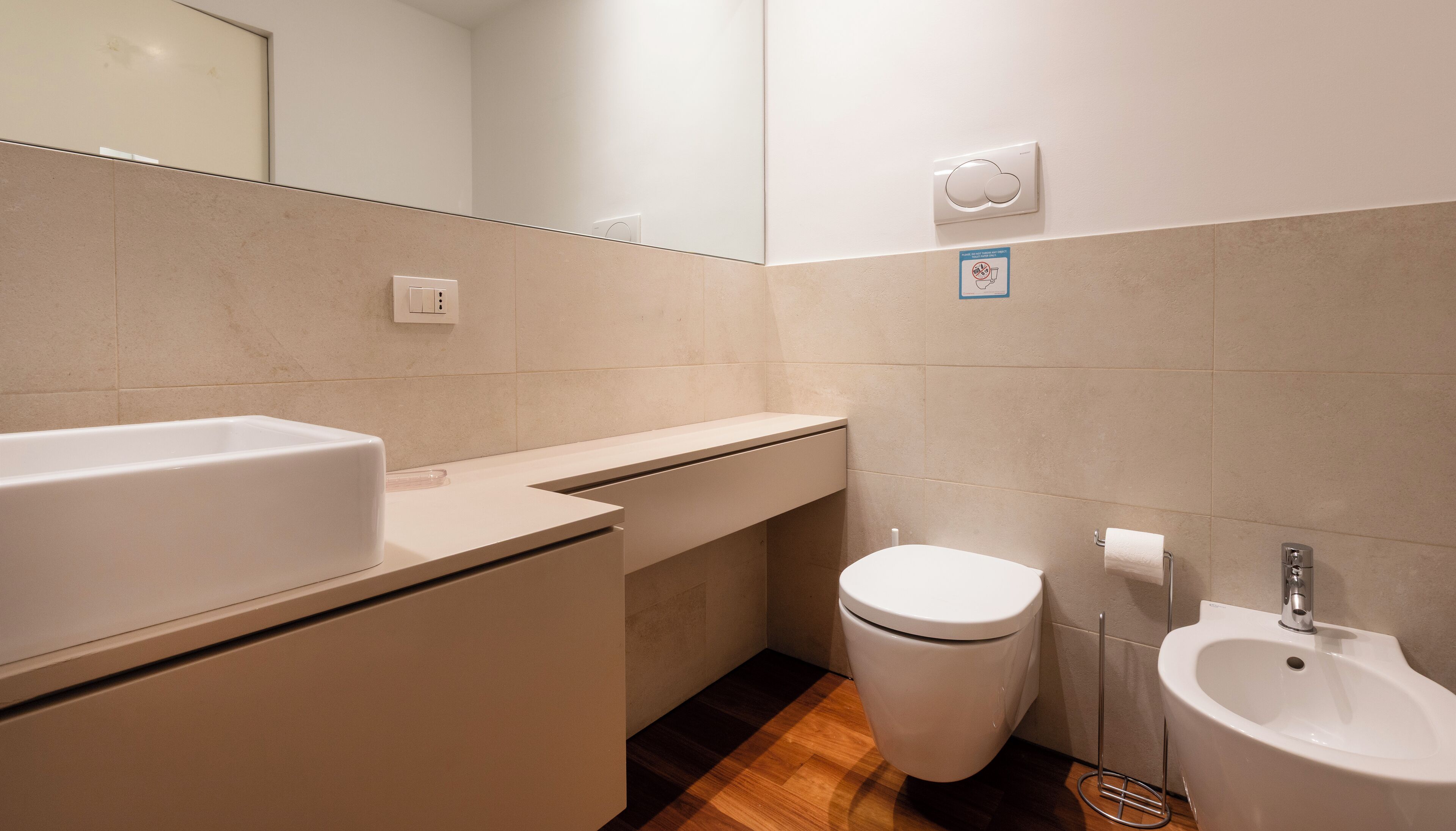 Ein Badezimmer mit Waschbecken, Toilette, Bidet und Spiegel.