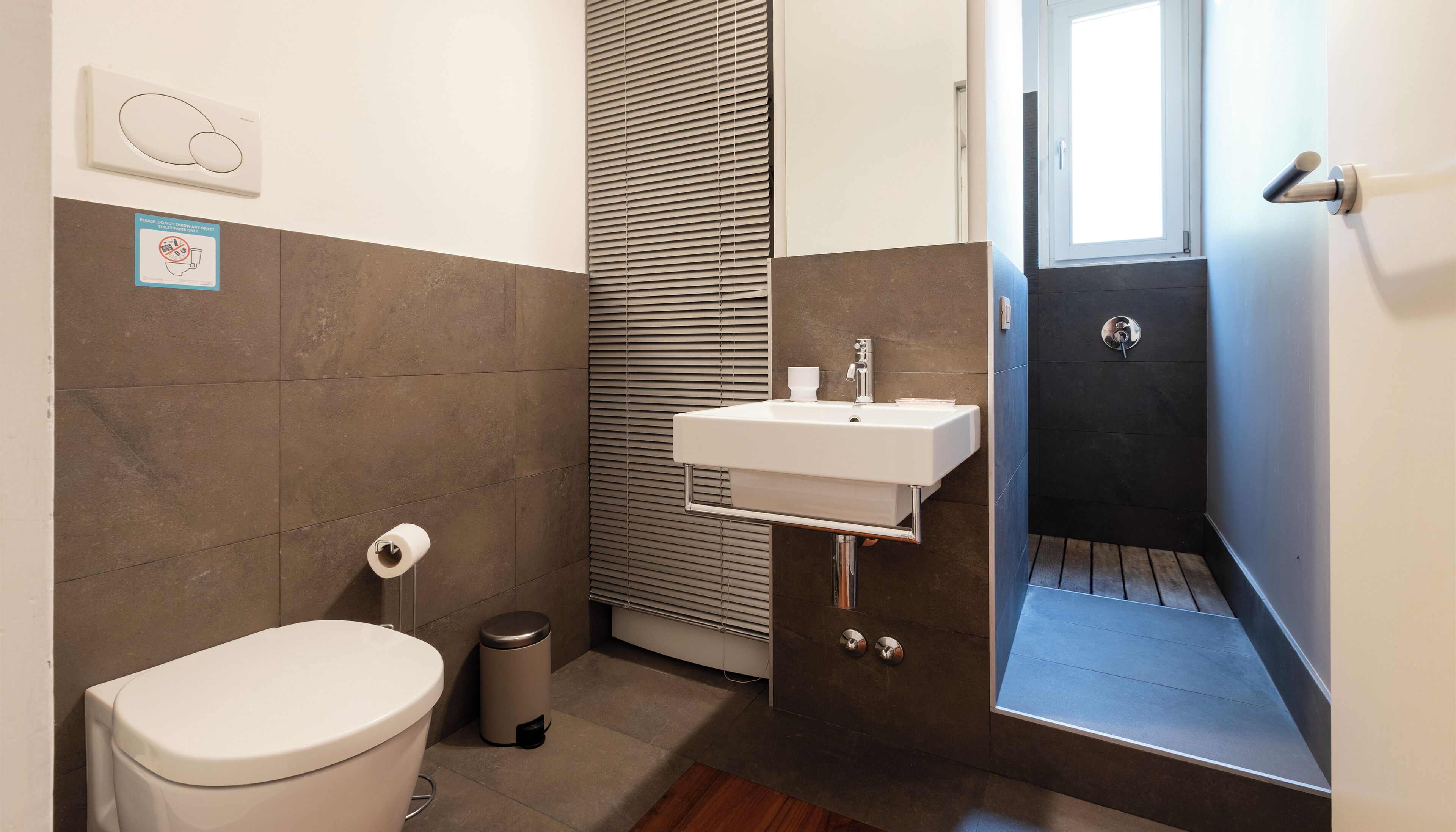A bathroom with a toilet, sink, and shower.