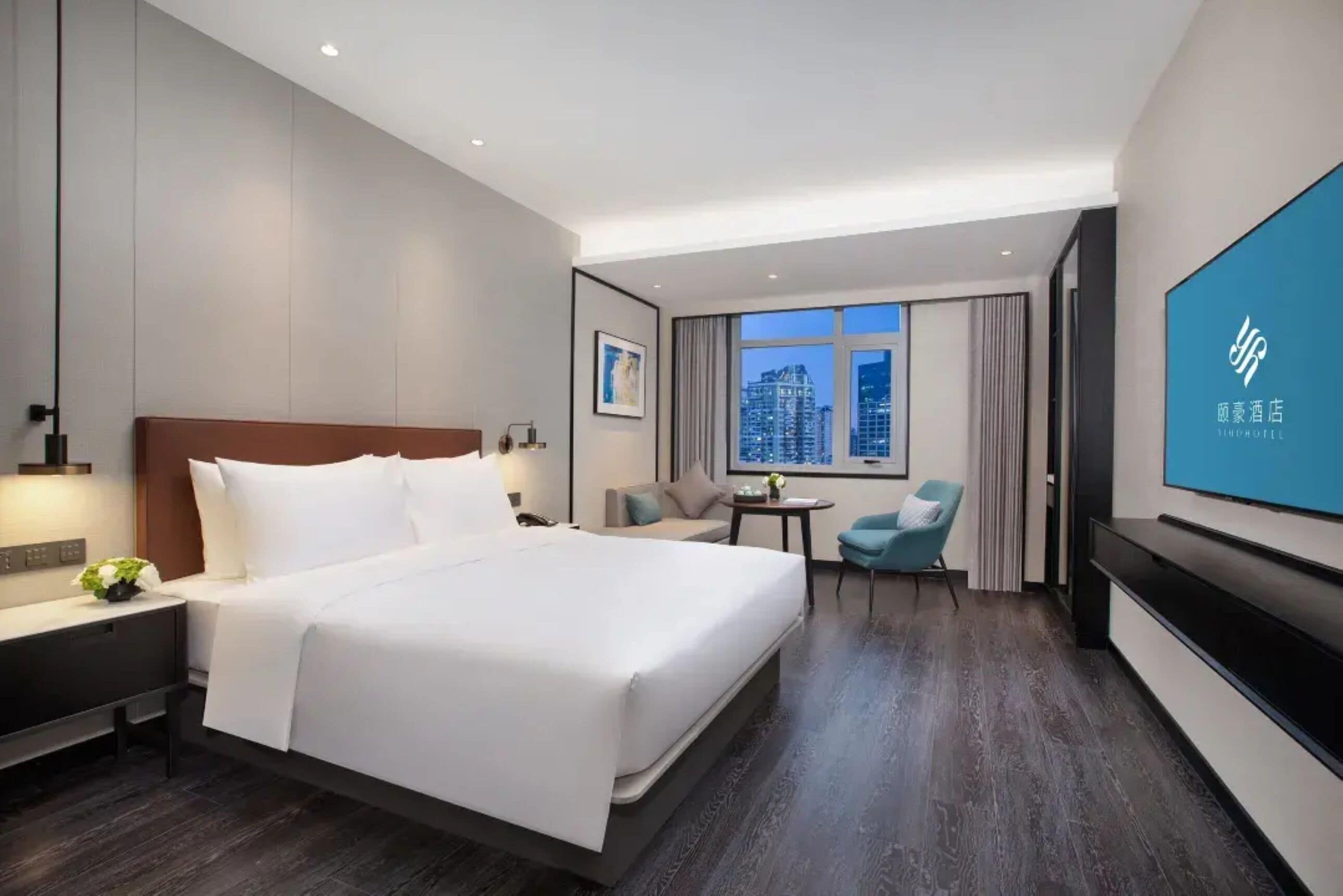 Une chambre d’hôtel avec un grand lit, une télévision, un bureau et une chaise.