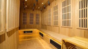A sauna room with wooden walls, benches, and a tiled floor.