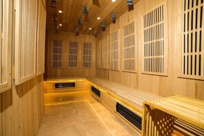 Un sauna con paredes de madera, bancos y piso de baldosas.