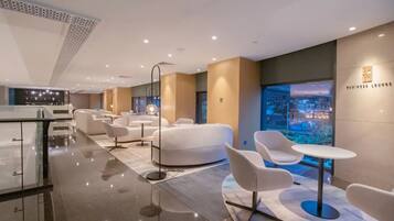 A modern lounge area with seating and a view of the cityscape.