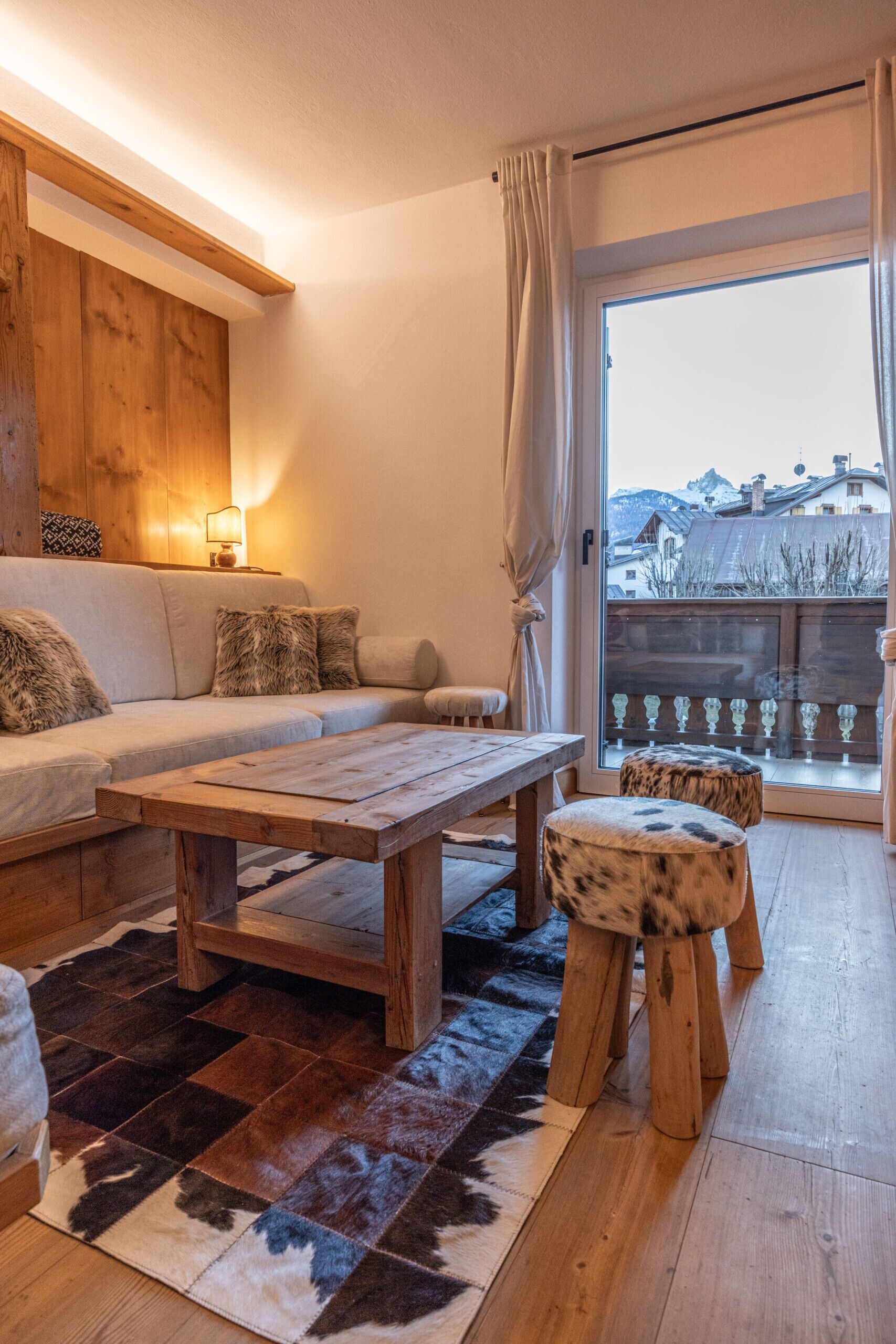 A cozy living room with a wooden coffee table, a sofa, and a patterned rug.