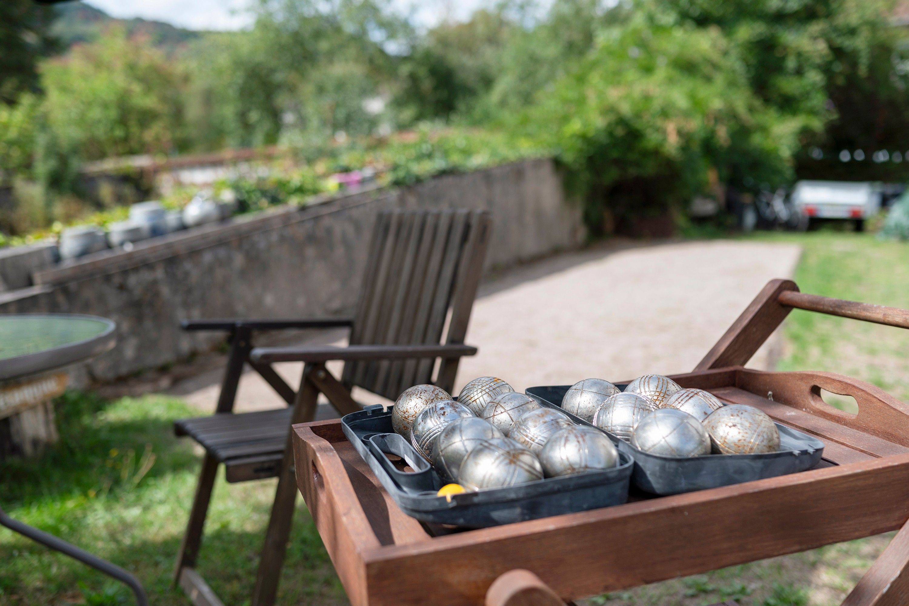 Un banc en bois avec un plateau contenant des billes d’argent.