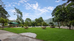 Un área verde bien cuidada con mesas de picnic y un pabellón.