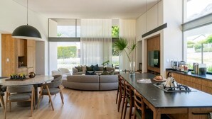 A modern kitchen with a central island, wooden cabinets, and a large window. - 6 on Heide (Franschhoek)