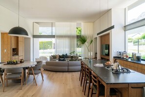 A modern kitchen with a central island, dining area, and seating. - 6 on Heide (Franschhoek)