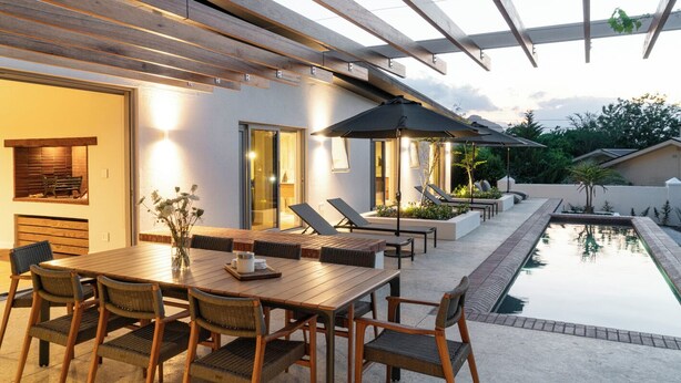 A modern outdoor patio with a dining table, chairs, and lounge areas. - 6 on Heide (Franschhoek)
