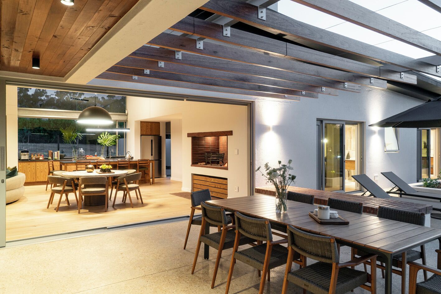 A modern kitchen with wooden cabinets and a dining area with a large table and chairs.