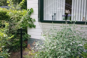 Ein Haus mit Fenster, einem Schild und umliegender Bepflanzung.