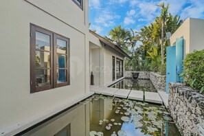 A modern building with a water feature and a stone wall.