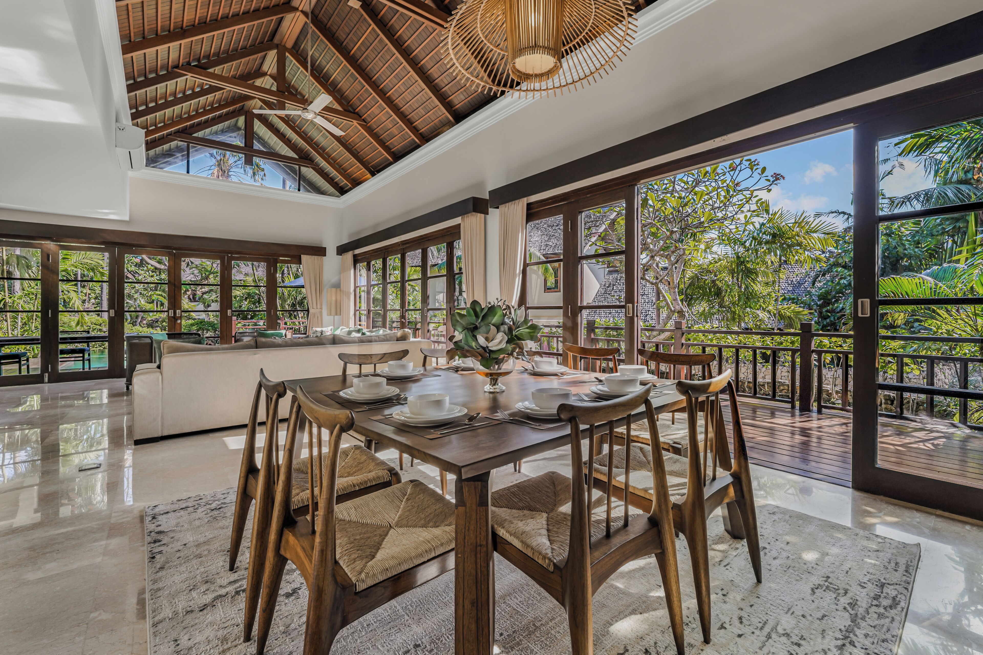 Ein großzügiger Essbereich mit hoher Decke, großen Fenstern und Blick ins Freie.