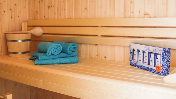 A wooden sauna bench with a wooden bucket and a box of wellness products. - SEEside13. Lake view. Sauna. Front Row at Diemelsee (Diemelsee)