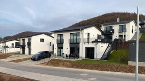 A modern residential building with a flat roof, large windows, and a staircase leading to a second floor. - SEEside13. Lake view. Sauna. Front Row at Diemelsee (Diemelsee)