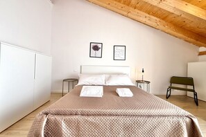 A bedroom with a bed, a bench, a wardrobe, and a wall with two framed pictures. - [Il Parco Apartment 7] Natura & Relax-RoadTo5Terre (Beverino)