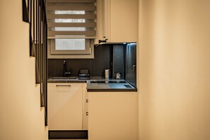 A compact kitchen with a built-in oven, a coffee maker, and a microwave. - Urban Metro Flats in Thessaloniki- Anesis (Thessaloniki)
