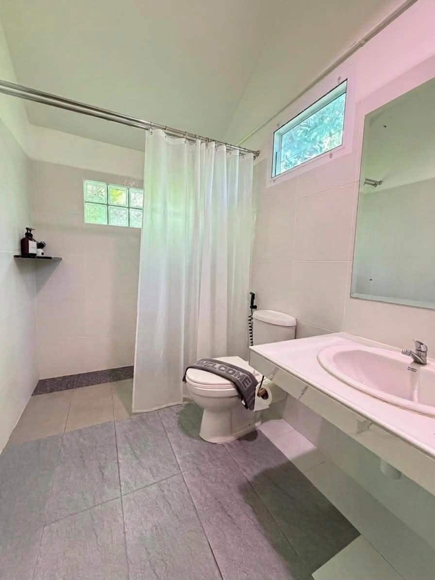 A bathroom with a shower, toilet, and sink.