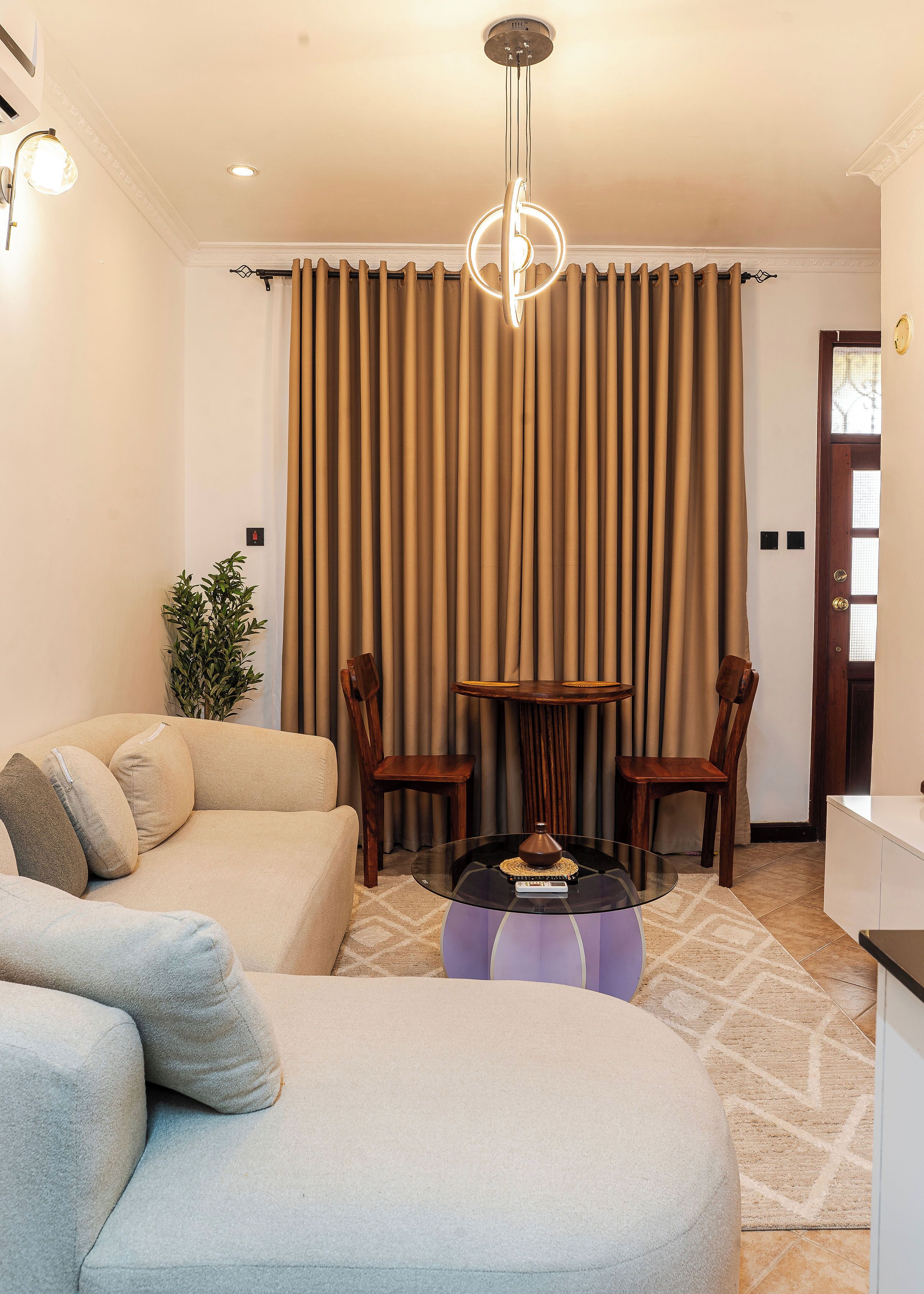 A living room with a sofa, chairs, a coffee table, and a curtain.