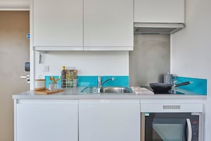 A modern kitchen with a built-in oven, a sink, and a stove. - Student Only Felda House Wembley (Wembley)