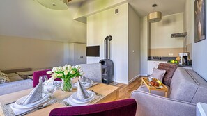 Una sala de estar moderna con comedor, sofá, mesa de centro y chimenea.