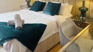 A hotel room with a large bed, two bedside lamps, a glass table, and a modern headboard. - Villa Chayofa (Chayofa)
