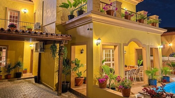 A two-story building with a balcony, potted plants, and a pool. - Villa Chayofa (Chayofa)