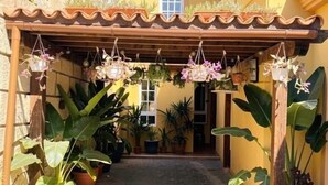 A courtyard with a pergola, potted plants, and a building entrance. - Villa Chayofa (Chayofa)