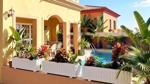 A two-story building with a swimming pool, outdoor seating, and potted plants. - Villa Chayofa (Chayofa)