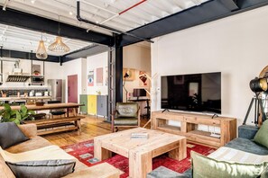 Ein modernes Wohnzimmer mit einem großen Flachbildfernseher, Holzmöbeln und einem roten Teppich.