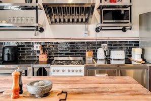 A modern kitchen with a gas stove, microwave, and stainless steel appliances. - Central City 2bed with Mountain Views Skywood Loft (Cape Town)