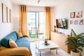 Ein modernes Wohnzimmer mit einer Couch, einem Couchtisch und einem Fernseher.