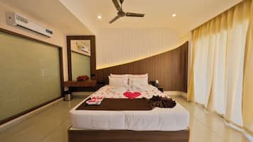 Ein modernes Schlafzimmer mit einem großen Bett, einem Deckenventilator und einer Wand-Klimaanlage.