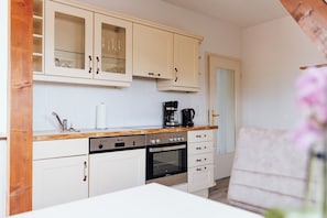 A kitchen with white cabinets, a coffee maker, and a dishwasher.